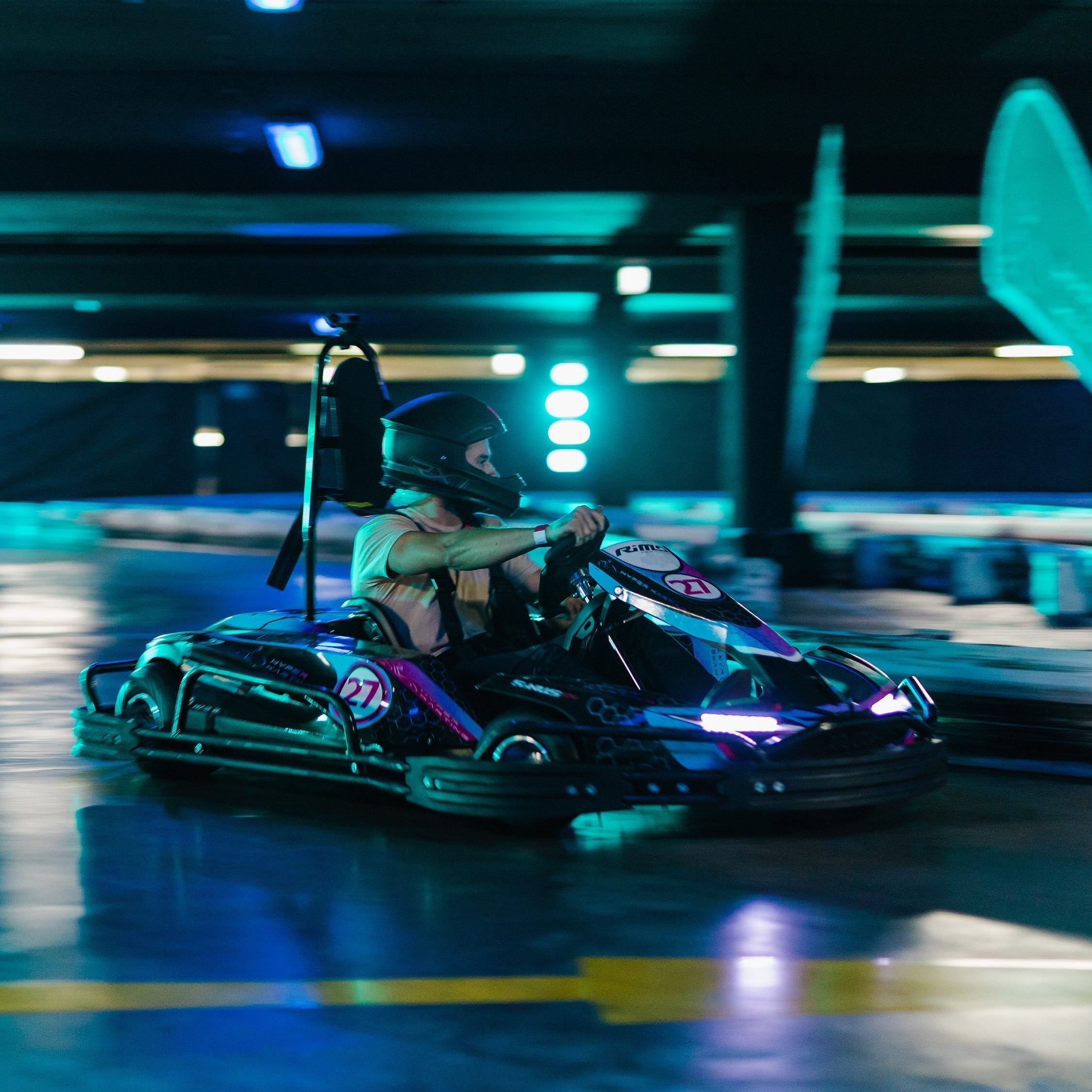 Man in helmet driving go kart around a turn